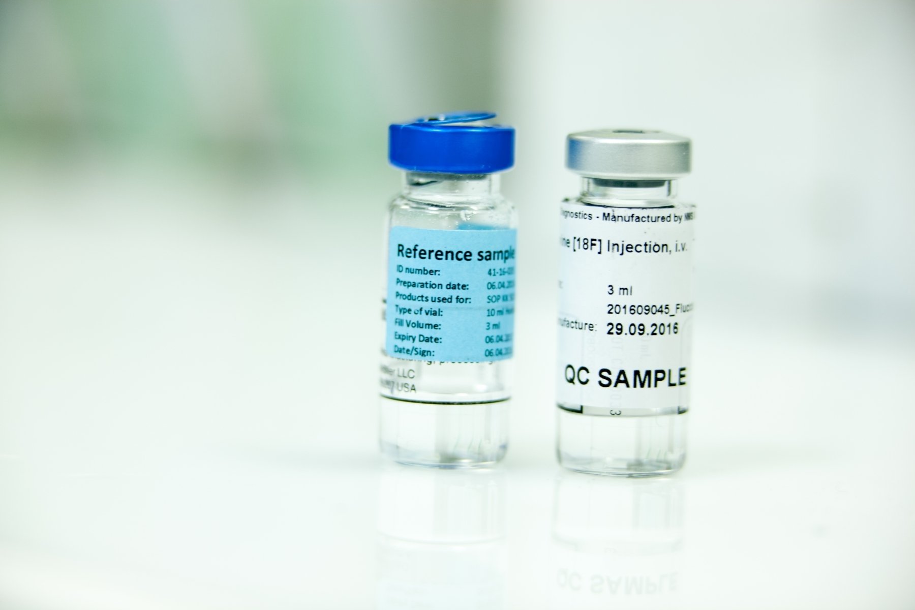 Two labelled vials containing medical or chemical reference and quality control samples.