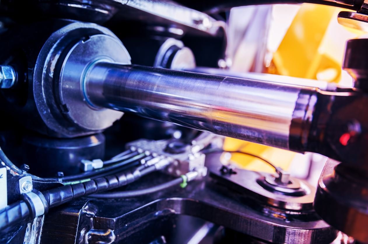Close-up of a hydraulic piston system in industrial machinery with metallic components.