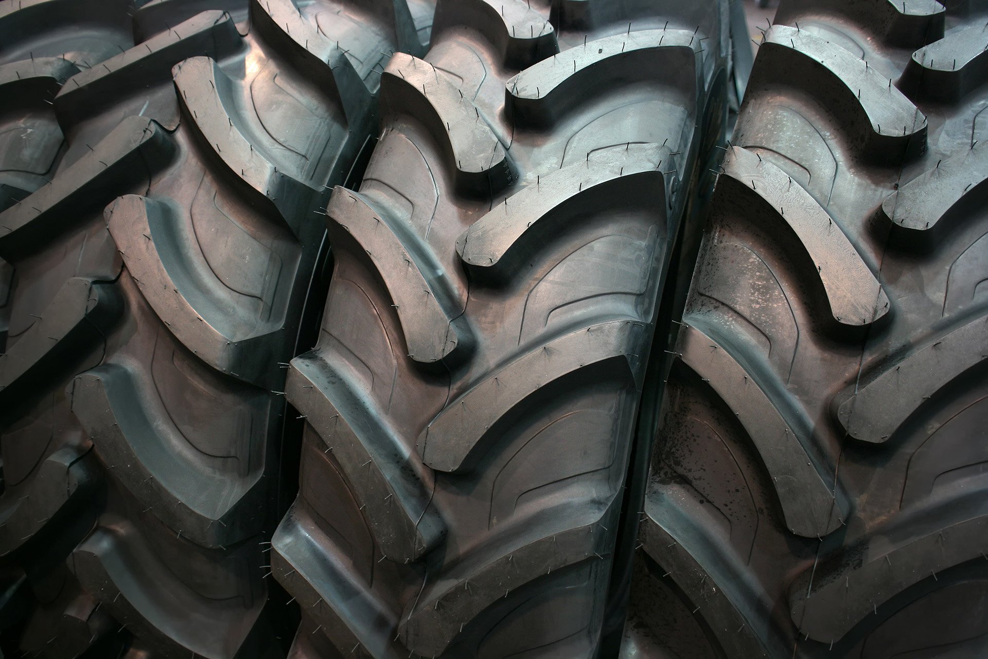 Close-up view of large black tractor tires with deep treads.