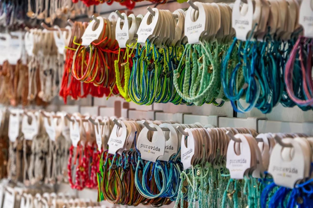 Display of colorful bracelets hanging on racks in a retail store.