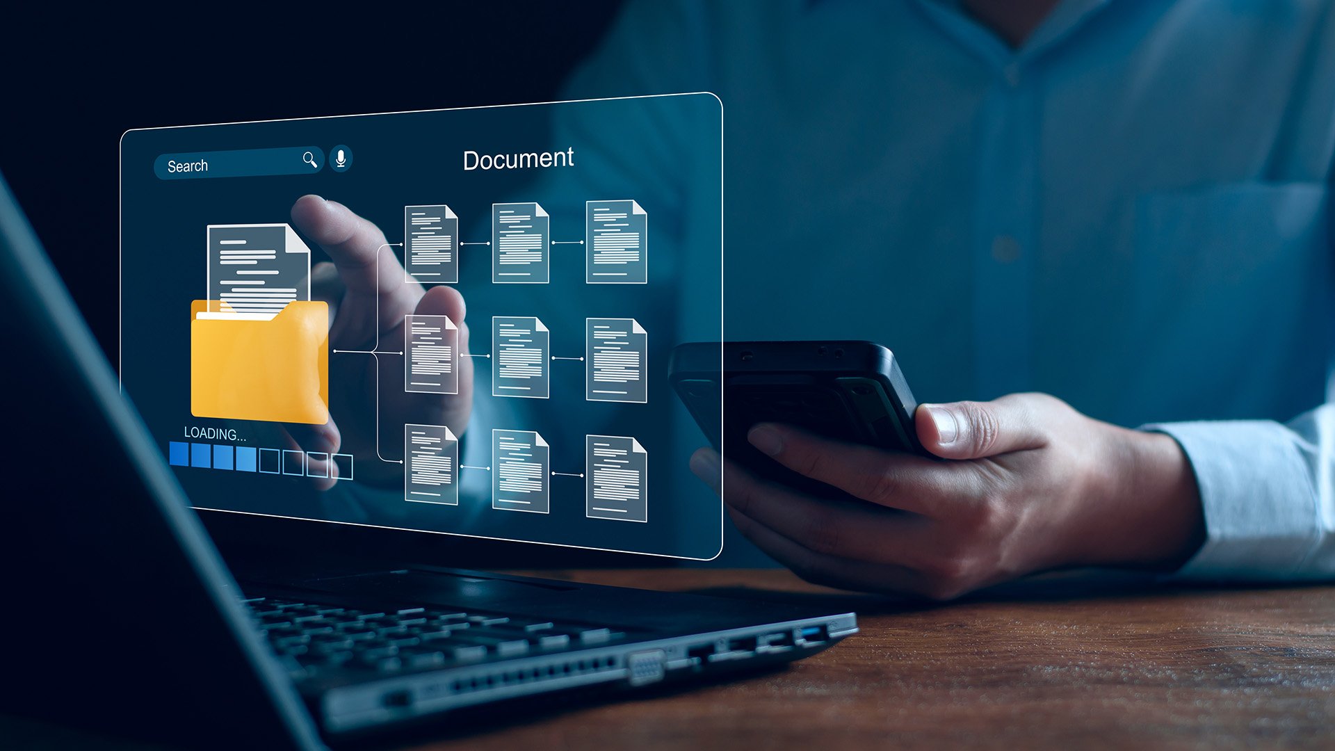 A person using a smartphone while interacting with a digital document interface on a laptop, featuring a yellow folder and loading screen.