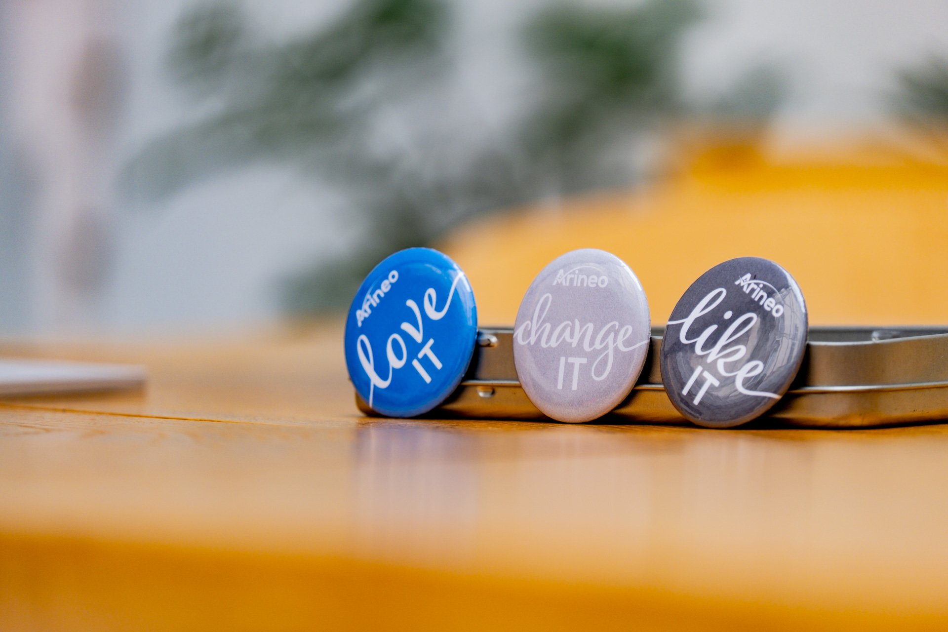 Three buttons on a wooden table displaying 